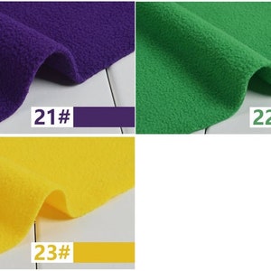May include: Close-up of three swatches of fleece fabric in purple, green, and yellow. Each swatch has a corresponding color-matched rectangle with a number. The purple swatch is labeled "21#", the green swatch is labeled "22#", and the yellow swatch is labeled "23#".