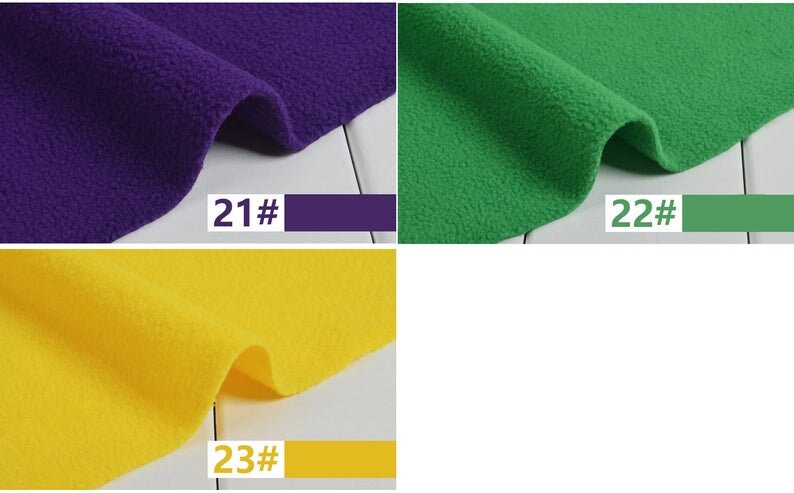 May include: Close-up of three swatches of fleece fabric in purple, green, and yellow. Each swatch has a corresponding color-matched rectangle with a number. The purple swatch is labeled "21#", the green swatch is labeled "22#", and the yellow swatch is labeled "23#".