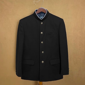 May include: A black blazer with a mandarin collar and gold buttons. The blazer has a single pocket on the left side and a single button closure at the bottom.