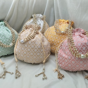 Side view of handcrafted silk potli bag showcasing detailed embroidery pattern and fine stitching quality. Designed with durable drawstring closure and decorative tassels, this ethnic clutch is perfect for weddings, bridesmaids gifts, festive events and traditional outfits. Lightweight yet spacious for carrying daily essentials stylishly.