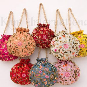 Puede incluir: Una colección de bolsos con cordón bordados en varios colores, incluyendo rosa, naranja, rojo, blanco, amarillo, azul y rosa. Cada bolso presenta patrones florales y correas de cadena doradas.