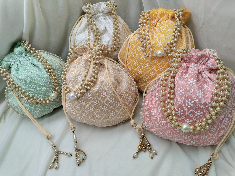 Set of multiple handmade embroidered potli bags arranged beautifully, perfect for bulk wedding favors, return gifts and party giveaways. Ideal for Indian weddings, baby showers and festive gifting. Uniform design, premium quality fabric and elegant finish make it a perfect bulk purchase option.