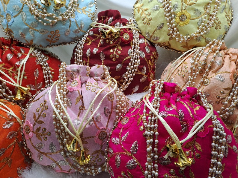 Colorful silk potli bags with heavy gold zari embroidery and pearl handle detailing, handcrafted Indian drawstring pouch for women, luxury ethnic handbags suitable for bridal wear, wedding parties, festive gifting, diwali celebrations, unique return gift ideas, elegant traditional purse for saree and lehenga outfits, bohemian style accessory popular among USA buyers for handmade and artisan fashion products