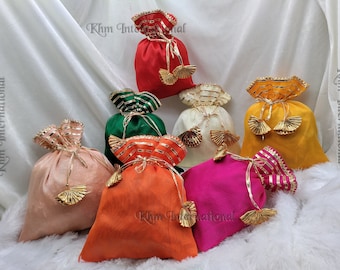 May include: Assortment of colorful drawstring bags with gold trim and tassels. The bags are made of a soft, silky fabric and are perfect for gift wrapping or storing small items.