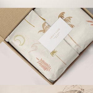 May include: A white box with a brown cardboard box inside. The boxes are decorated with a tropical theme featuring palm trees and the text "Coco & Sand".