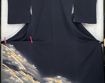 May include: A dark navy blue kimono with a decorative pattern of gold and white bamboo and waves. The kimono is displayed in a black frame. The bottom of the kimono has a gradient effect.