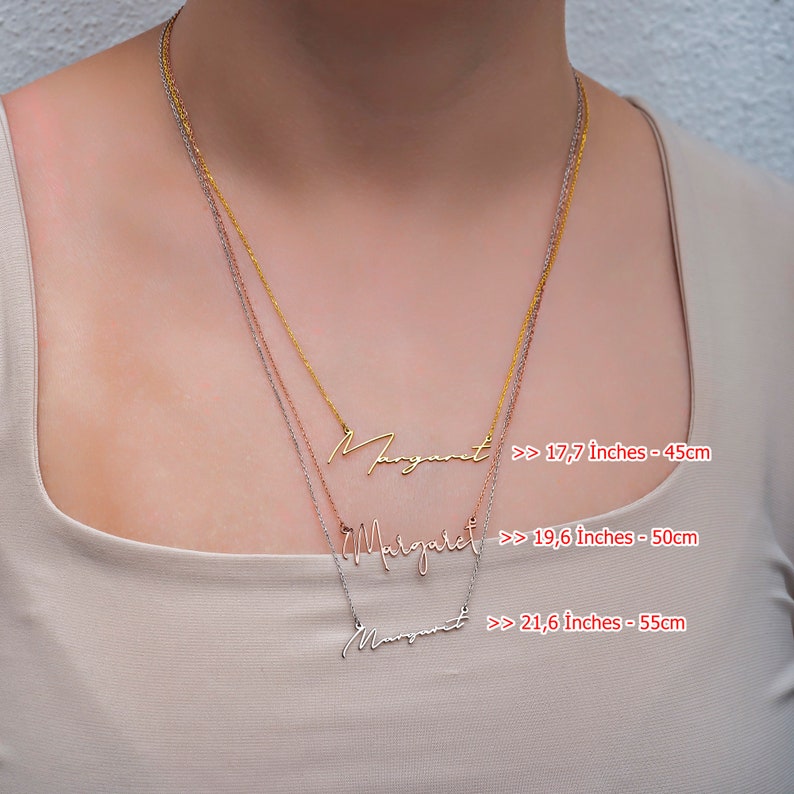 May include: Three gold, silver, and rose gold necklaces with the name "Margaret" written in cursive on each. The necklaces are shown on a model wearing a beige top. The necklaces are available in three lengths: 17.7 inches (45 cm), 19.6 inches (50 cm), and 21.6 inches (55 cm).