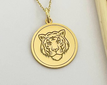 May include: Gold pendant necklace featuring a round charm with an engraved tiger face.