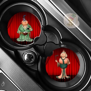 Pu&ograve; includere: Sottobicchieri per auto con personaggi dei cartoni animati davanti a tende rosse. Un personaggio indossa un vestito verde e tiene in mano una ciotola, mentre l'altro indossa un abito rosa e verde e tiene in mano un ventaglio. I sottobicchieri sono in una console nera.