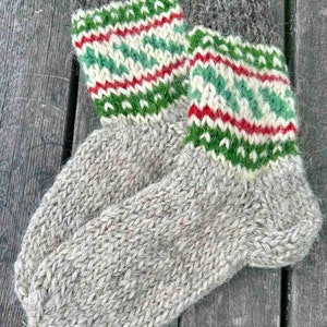 May include: A pair of gray wool socks with green, red, and white patterned cuffs. The socks are knitted and have a fuzzy texture.