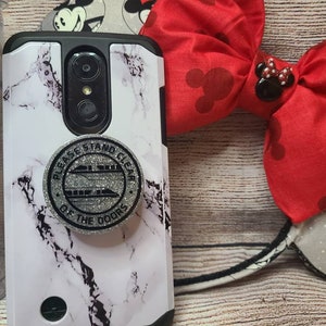 May include: A white and black marble phone case with a black and silver phone grip. The phone grip has the text "Please Stand Clear of the Doors" with a graphic of a train.