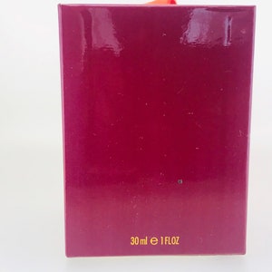 May include: A burgundy box with gold lettering that reads "30 ml e 1 FLOZ".