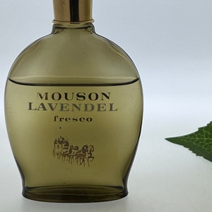 Op de afbeelding: Een bruine glazen fles Mousson LavendeL fresco cologne. De fles heeft een gouden dop en een gouden etiket met de productnaam en het woord "fresco".