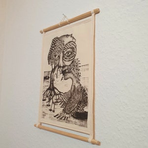 May include: A black and white illustration of a surreal creature with a human face and bird-like wings, printed on a canvas and mounted on a wooden frame.