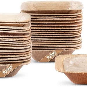 May include: A stack of 25 square-shaped, disposable, palm leaf bowls. The bowls are made from natural materials and are biodegradable. The bowls are stacked on top of each other and are ready to be used. The bowls are brown in colour and have a natural, rustic look. The bowls are perfect for serving appetisers, desserts, or snacks. The bowls are also great for parties, picnics, or other outdoor events. The bowls are made by Foogo.