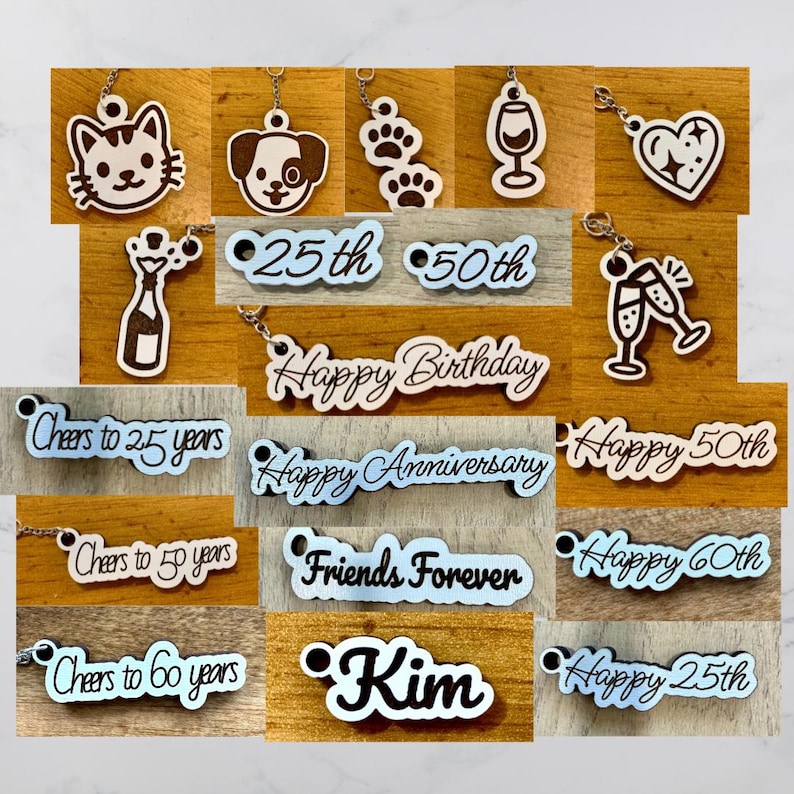May include: A selection of wooden keyrings with diverse designs. Includes a cat, dog, paw prints, wine glass, heart, champagne bottle, and phrases such as "Happy Birthday" and "Friends Forever." Some keyrings feature numbers.