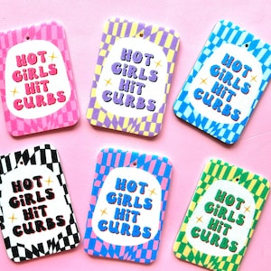 May include: Six colorful air fresheners with a checkered pattern and the text "Hot Girls Hit Curbs".