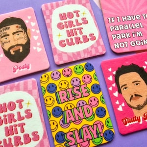 May include: Six pink and yellow car air fresheners with various designs and text. The designs include a smiley face pattern, a pink and white checkered pattern, and a pink heart pattern. The text includes "Hot Girls Hit Curbs", "Rise and Slay", "If I Have To Parallel Park I'm Not Going", and "Slutty 9".