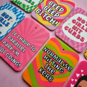 May include: A set of colorful car air fresheners with humorous phrases like "Hot Girls Hit Curbs", "Beep Beep Bitch!" and "Normalise Hitting the Kerb".