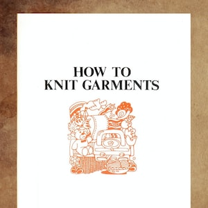 以下が含まれることがあります： 「HOW TO KNIT GARMENTS」という黒い文字が書かれた本の表紙。表紙の中央には、オレンジ色のテディベア、糸、その他の編み物用品のイラストが描かれている。表紙の下部には、「Compiled by THE SILVER KNITTING INSTITUTE, Tokyo, Japan」という文字が書かれている。