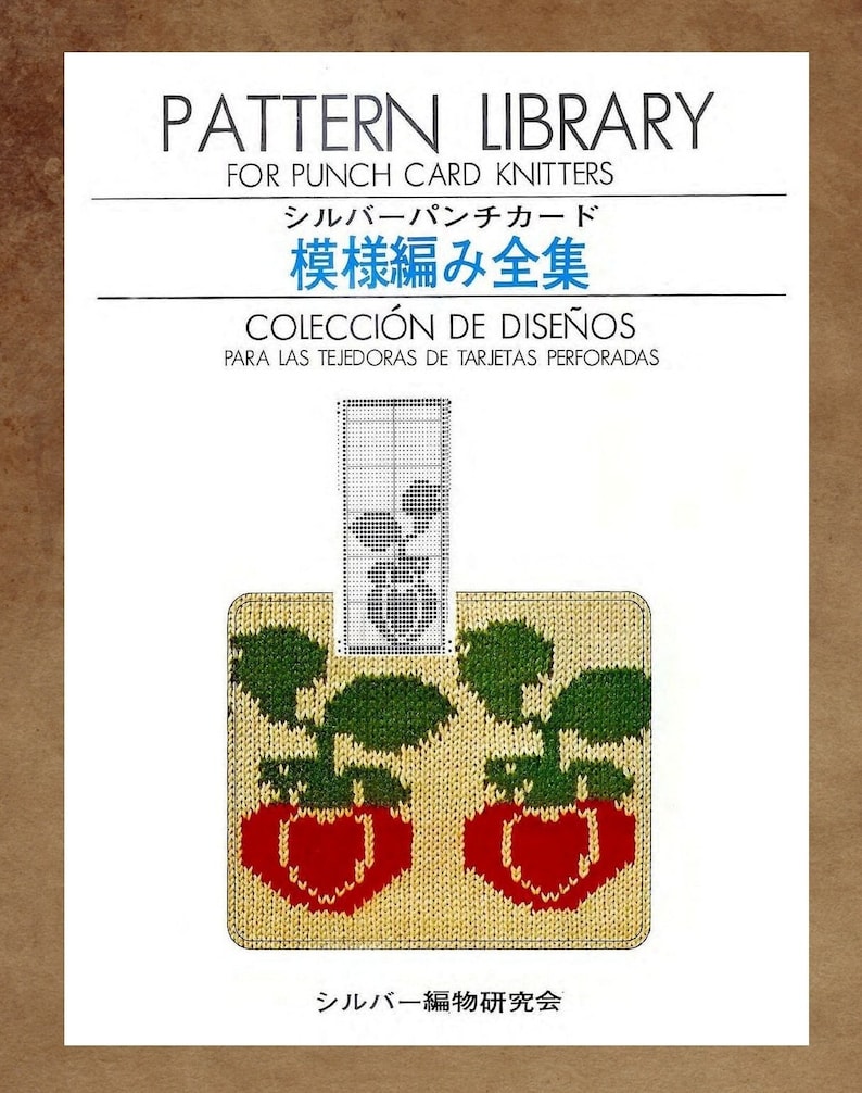May include: A book cover with the title "Pattern Library" for punch card knitters. The cover features a colorful illustration of two strawberries with green leaves.
