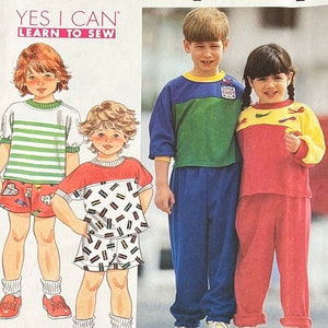 May include: A sewing pattern for children's clothing. The pattern includes instructions for making a striped shirt, a patterned shirt and shorts, a green and blue striped shirt and blue pants, and a red and yellow striped shirt and red pants. The pattern is titled "Yes I Can Learn to Sew."