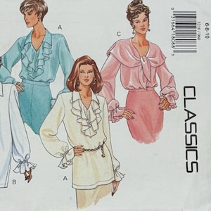 May include: Vintage sewing pattern featuring illustrations of women's blouses and tops. The designs include various styles with ruffled details, long sleeves, and different necklines. The color palette includes white, blue, and pink.