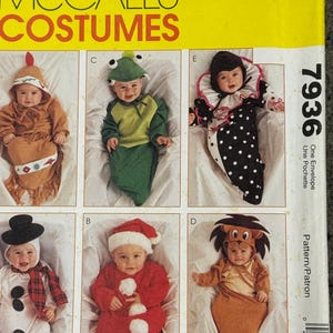 May include: McCall's Costumes pattern featuring six baby Halloween costumes. Costumes include a chicken, frog, clown, snowman, Santa, and lion. The pattern fits infants in sizes small through large.