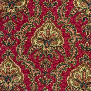 May include: Close-up of a red fabric with an ornate, repeating pattern. The design features stylized floral and paisley elements in shades of gold, green, and red, creating a rich, textured appearance. The overall aesthetic is reminiscent of vintage textiles.