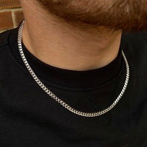 May include: A silver curb chain necklace. The chain is made of metal and has a classic curb link design.