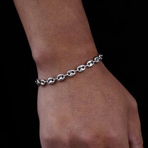 May include: A silver chain bracelet with a mariner link design.