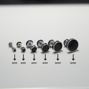 Op de afbeelding: Een set van zeven zwarte en zilveren oorbel studs in de maten 3 mm, 4 mm, 6 mm, 8 mm, 10 mm en 12 mm.