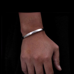 Peut inclure: Un bracelet en argent sur le poignet d'une personne.