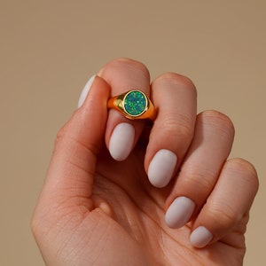 Peut inclure: Une bague en or avec une opale ovale verte.