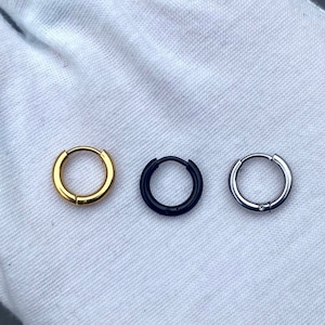 Puede incluir: Tres pendientes de aro en diferentes acabados: dorado, negro y plateado.