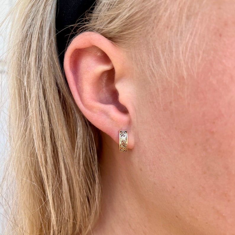 May include: Gold hoop earrings with a delicate floral design.