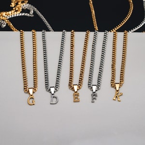 May include: Five gold and silver chain necklaces with letter pendants. The letters are G, D, E, F, and K.