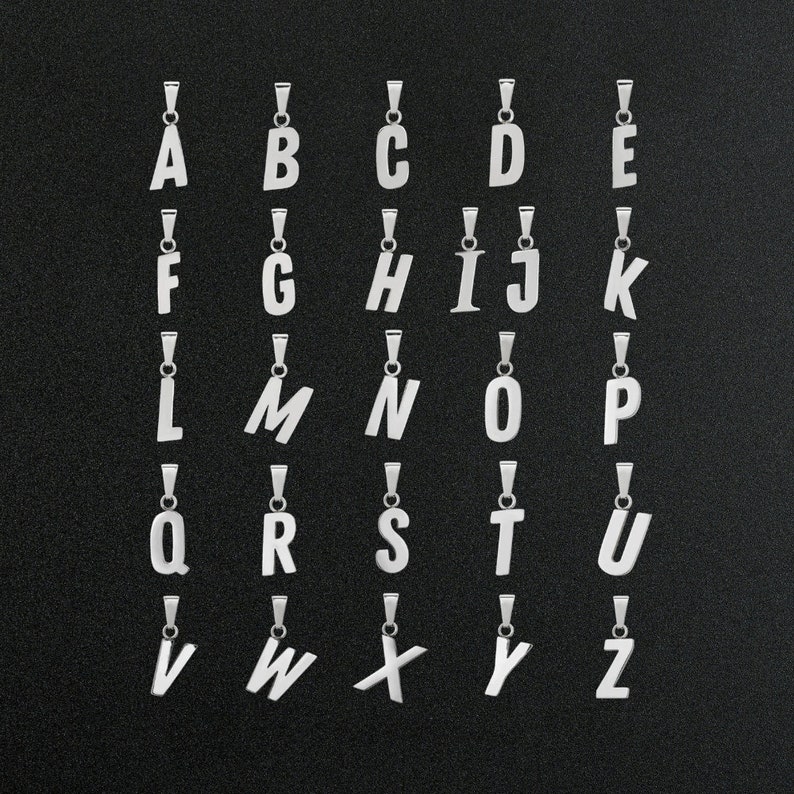 May include: A set of 26 silver letter charms, each featuring a different letter of the alphabet. The charms are arranged in alphabetical order on a black background.