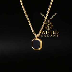 May include: A gold-colored necklace with a black square pendant. The pendant is framed in gold and hangs from a rope chain. The brand name "TWISTED PENDANT" is displayed in gold text.