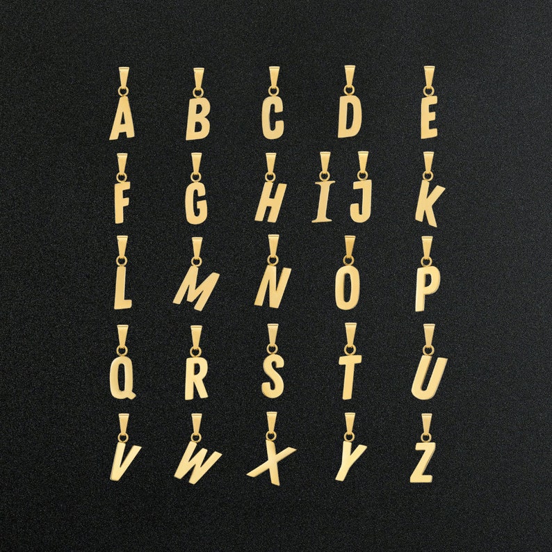 May include: Gold-colored alphabet letter pendants, A through Z, on a black background. Each letter is on a separate pendant.