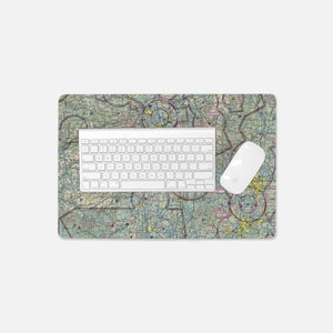 May include: A green and brown sectional aeronautical chart printed on a mouse pad. A white keyboard and mouse are on top of the mouse pad.