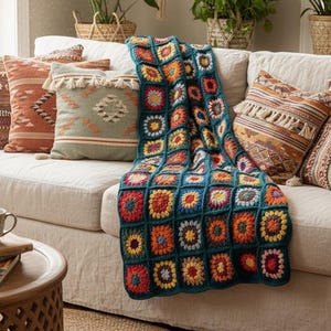 Può includere: Un accogliente soggiorno con un divano color crema adornato da cuscini decorativi e una colorata coperta all'uncinetto. La coperta presenta un design patchwork con vivaci quadrati rossi, arancioni, gialli e blu. Le piante in vaso aggiungono un tocco naturale.