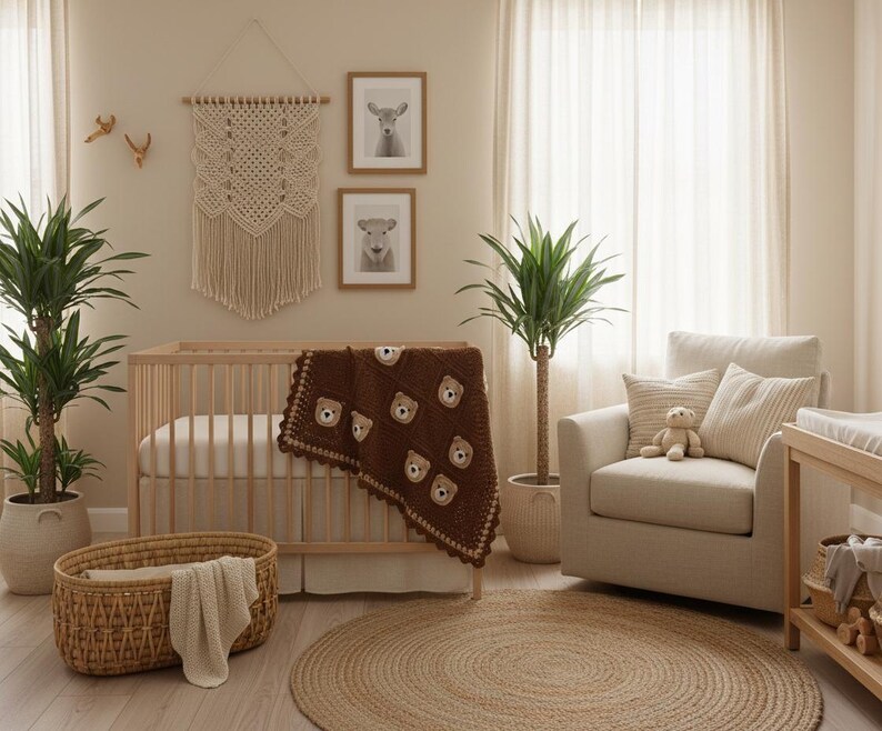 May include: A dark brown crochet blanket featuring repeating bear face motifs, draped over a light wood crib. The blanket has a scalloped edge and is positioned in a room with a macrame wall hanging, a beige armchair, and a woven floor basket.