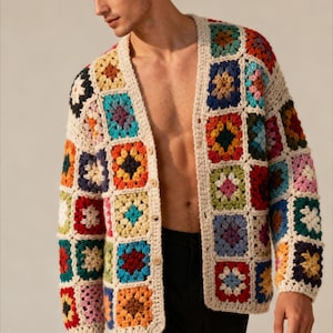 Può includere: Un cardigan all'uncinetto color crema con un design patchwork. I quadrati presentano una varietà di colori tra cui rosso, blu, verde, giallo e arancione. Il cardigan ha bottoni in legno e un bordo color crema.