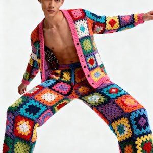 Puede incluir: Un conjunto de c&aacute;rdigan y pantalones de ganchillo con un patr&oacute;n de cuadrados de la abuela en colores vibrantes como rojo, azul, amarillo, verde y morado. El c&aacute;rdigan tiene un borde rosa y cierre de botones, y el pantal&oacute;n tiene cord&oacute;n ajustable.