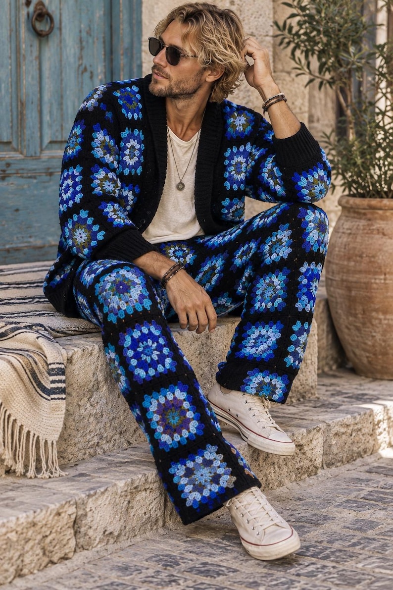 Puede incluir: Un conjunto de c&aacute;rdigan y pantal&oacute;n de ganchillo con base negra y motivos de cuadrados de la abuela en azul vibrante, azul claro y morado. El c&aacute;rdigan tiene cuello y pu&ntilde;os de canal&eacute; negro, combinado con zapatillas de lona blancas.