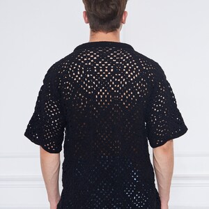 May include: A black crochet shirt with a loose fit and short sleeves. The shirt has a square pattern and is made of a lightweight material.
