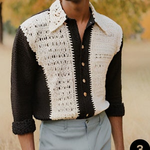 May include: A long-sleeved shirt in black and white with a crocheted design. The shirt has a button-up front and a collar.