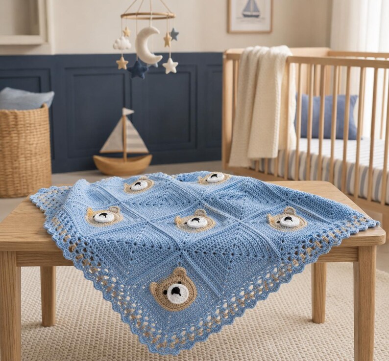 May include: A light blue crochet baby blanket featuring a repeating square pattern with centered, three-dimensional tan and white bear faces. The blanket has a decorative scalloped border and is constructed from yarn in a textured stitch.