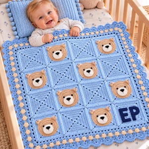 Pode incluir: Uma manta de bebé em croché azul-claro com uma grelha de painéis quadrados, cada um decorado com uma aplicação de cara de urso em bege e branco. A manta tem uma borda recortada com pequenos pompons beges e as letras EP bordadas em azul.